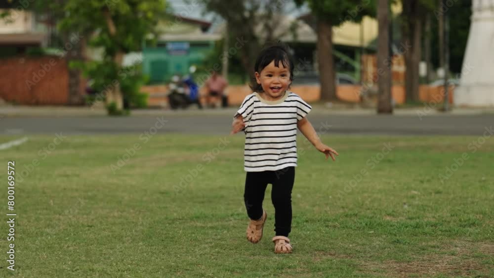 slow-motion of happy toddler girl running on grass field in the park slow-motion of happy toddler girl running on grass field in the park