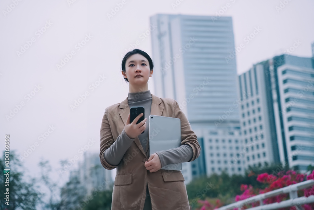 Confident Businesswoman With Tech in Urban Setting Confident Businesswoman With Tech in Urban Setting
