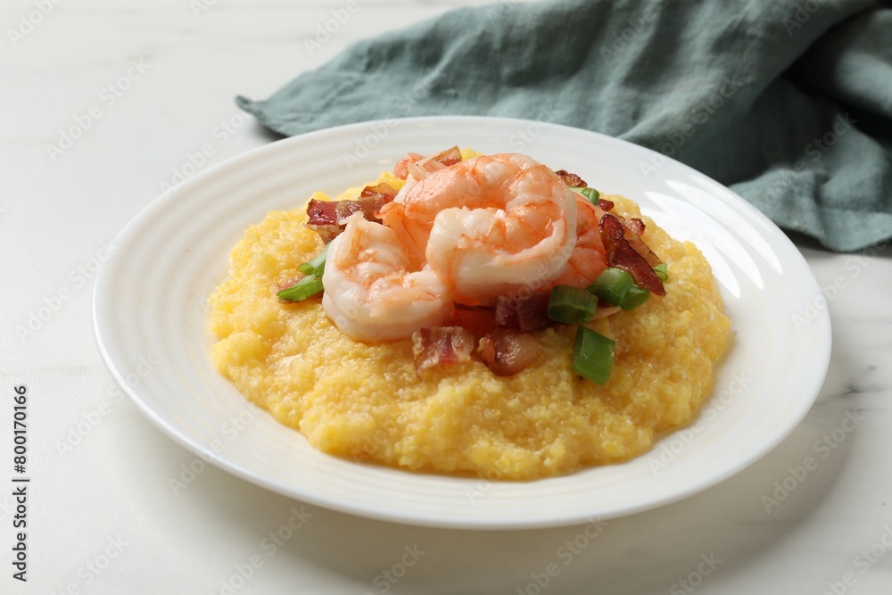 Plate with fresh tasty shrimps, bacon, grits and green onion on white marble table Plate with fresh tasty shrimps, bacon, grits and green onion on white marble table