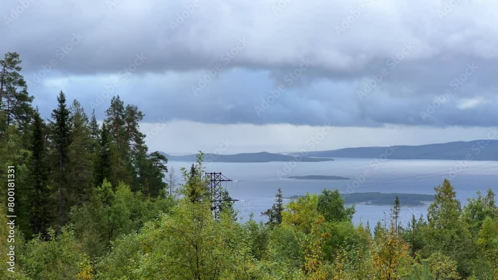 A cloudy day in the Murmansk region. Beautiful autumn view of the Kandalaksha Bay of the White Sea. Sunset on the White Sea coast in northern Russia.The sun is setting behind the sea and the mountains A cloudy day in the Murmansk region. Beautiful autumn view of the Kandalaksha Bay of the White Sea. Sunset on the White Sea coast in northern Russia.The sun is setting behind the sea and the mountains