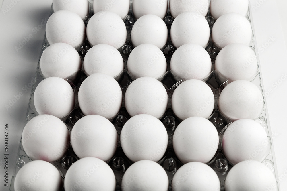 Raw white chicken eggs in tray on white background. Raw white chicken eggs in tray on white background.