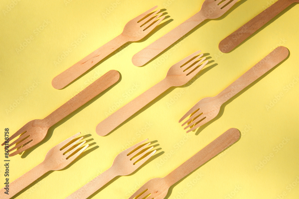 Fototapeta premium A wooden cutlery on a yellow background. Eco friendly, zero waste concept. Top view