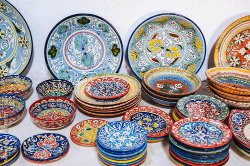 colorful east Uzbek ceramic plates hand-painted at oriental souvenir tableware bazaar in Uzbekistan