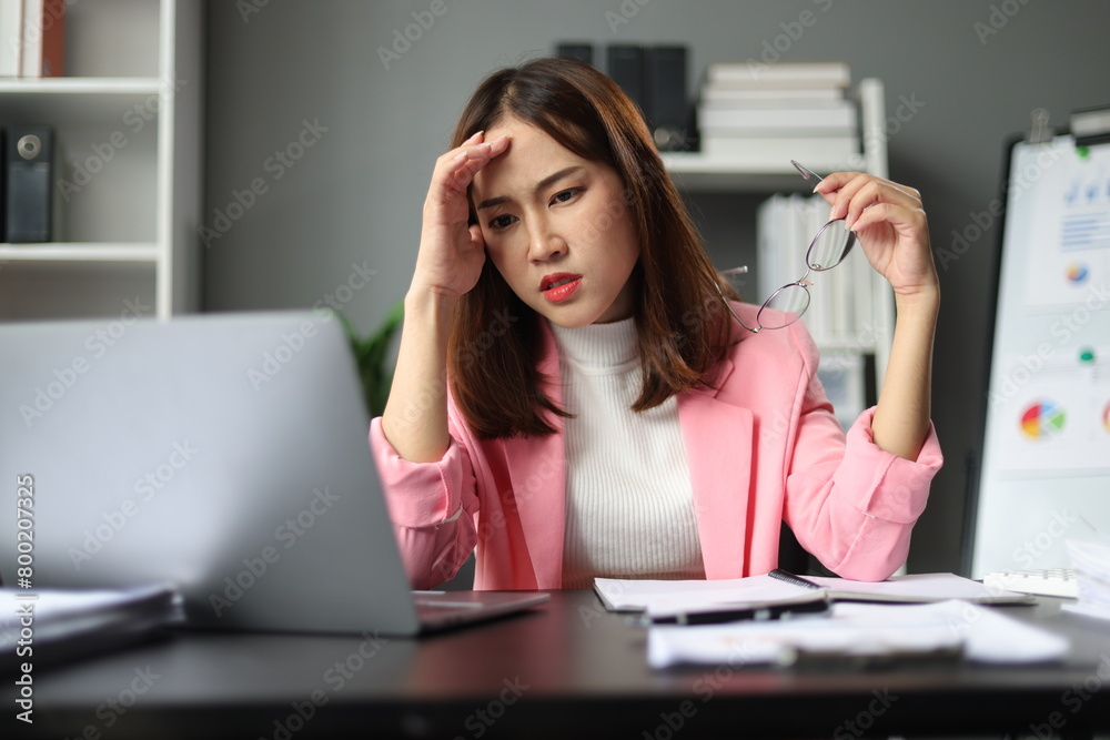 Businesswoman working with laptop in office, she is seriously working, is stressed and tired. Businesswoman working with laptop in office, she is seriously working, is stressed and tired.