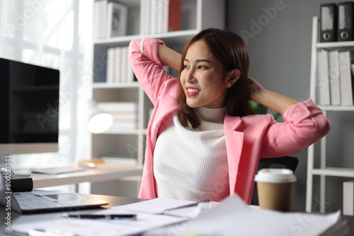 Woman working in office stretching during break to relieve fatigue.