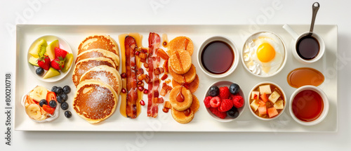 White plate with variety of breakfast foods including pancakes, bacon, cafe cup