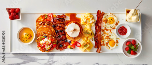 A white plate with variety of breakfast foods including crispy bacon, eggs, fluffy pancakes