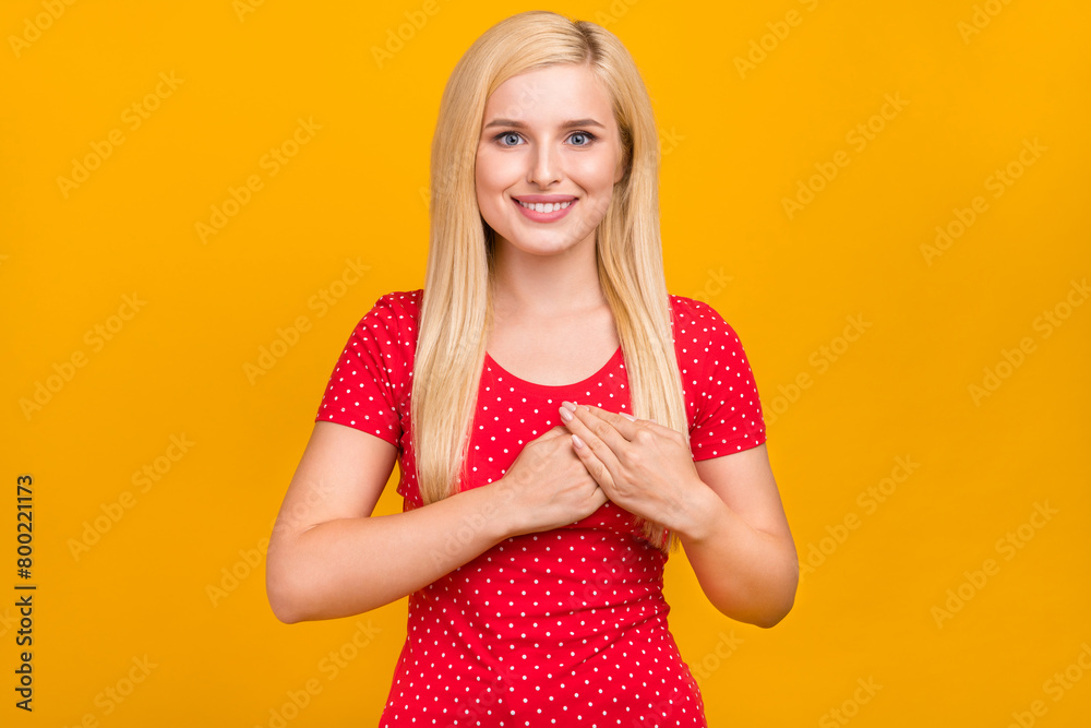 Photo portrait woman keeping hands on chest smiling isolated vivid orange color background Photo portrait woman keeping hands on chest smiling isolated vivid orange color background