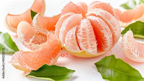 Red Pomelo or Grapefruit called Tabtim Siam in Thai, a sweet taste fruit with bright color planted in Asia, peeled beautifully with a pomelo skin and green leaves on white background. photo