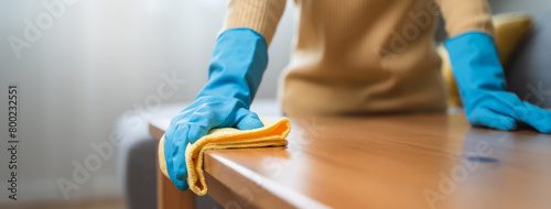 Foto happy Female housekeeper service worker wiping table surface by cleaner product to clean dust
