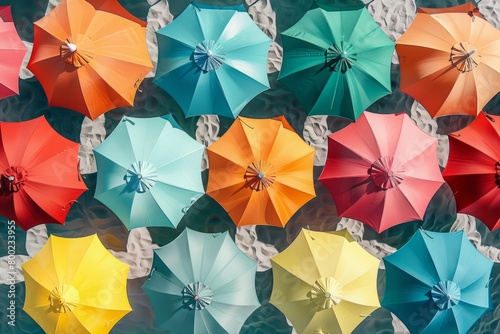 Overhead view of colorful beach umbrellas pattern on a sandy beach