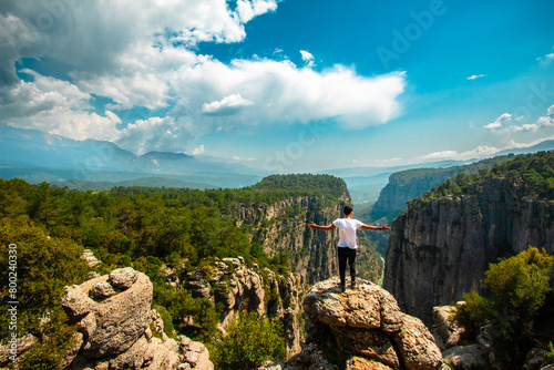 Fotografi Man opens his arms and watches the fascinating nature view