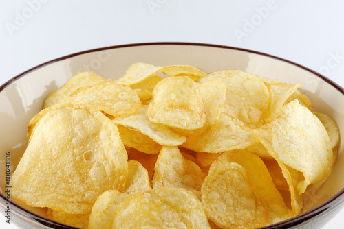Bowl of potato chips on white background.