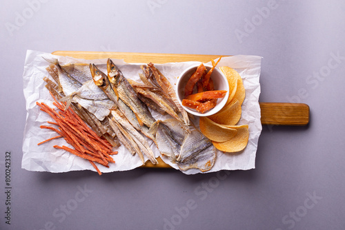 Dehydrated fish, carrots, and pumpkin on a white paper over grey background