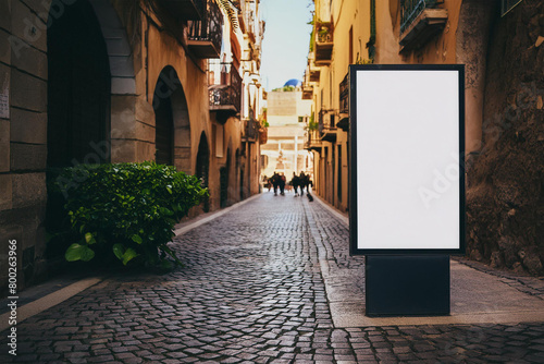 Outdoor mockup of a blank information poster on patterned paving-stone; an empty vertical street banner template in an alley; billboard placeholder mock-up on a city boulevard in an alleyway outdoors photo