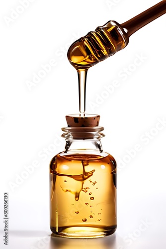 A jar of honey with a dipper, against a white backdrop Jar of honey and wooden drizzler isolated on white. photo