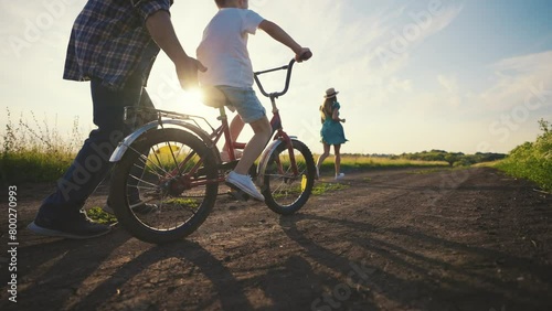 Wallpaper Mural Mom dad teaching son ride bike together in village on summer vacation. Parents running near child boy father holding bicycle clapping hands supporting kid. Family weekend on nature, running activity. Torontodigital.ca