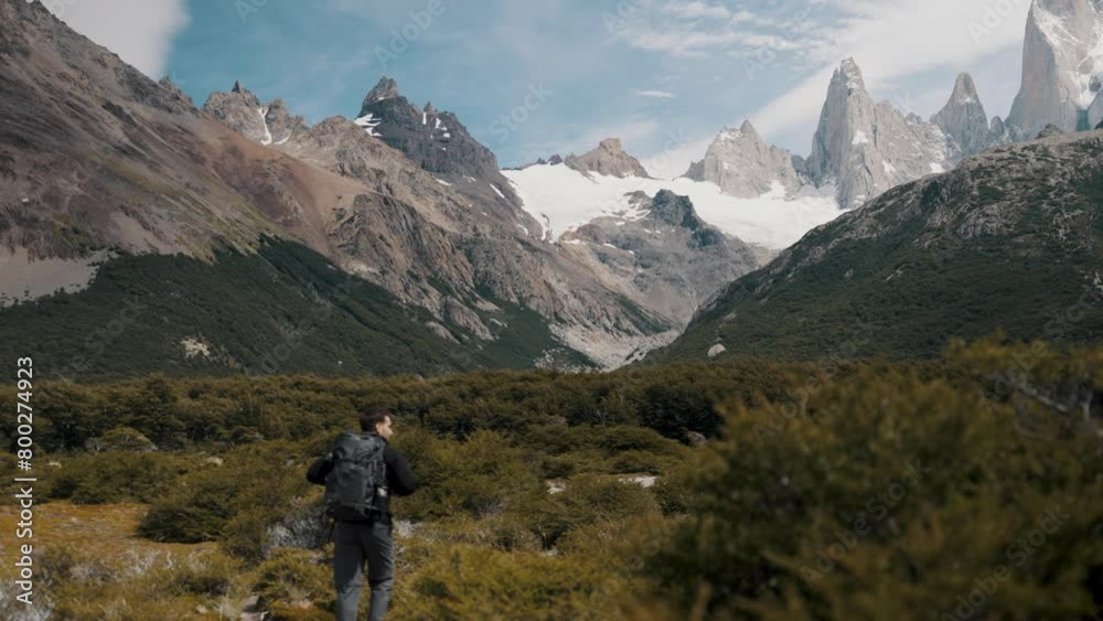 Male Backpacker Hiking Towards Monte Fitz Roy In Patagonia, Argentina - Wide Shot Male Backpacker Hiking Towards Monte Fitz Roy In Patagonia, Argentina - Wide Shot