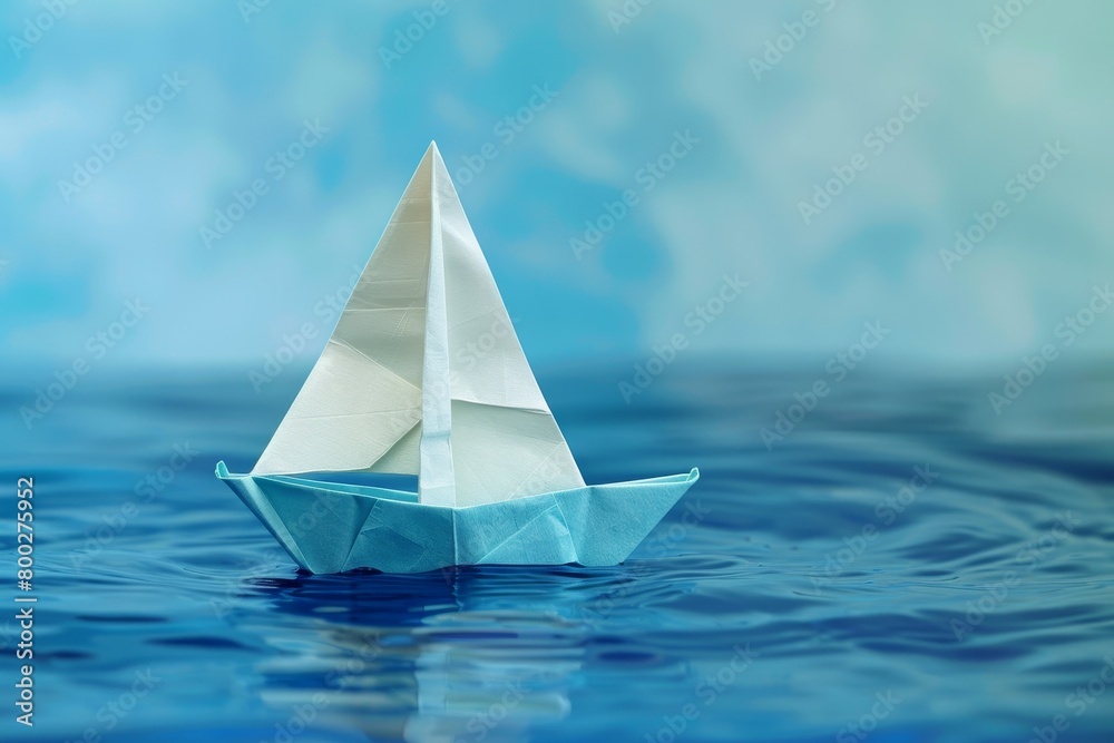 Origami sailboat on blue water Origami sailboat on blue water