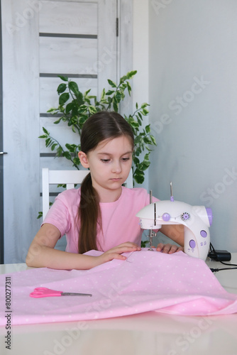Teenage girl prepares sewing machine for work, inserts thread. Hobby sewing as small business concept. Vertical photography.