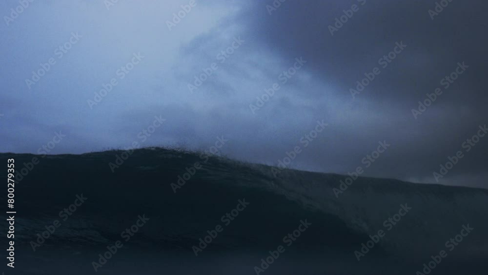 Ocean wave crashes spraying droplets into barrel, low angle view Ocean wave crashes spraying droplets into barrel, low angle view