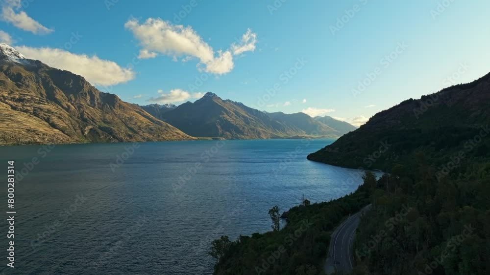 Aerial dolly along shaded side of Lake Wakatipu with mountains illuminated Aerial dolly along shaded side of Lake Wakatipu with mountains illuminated