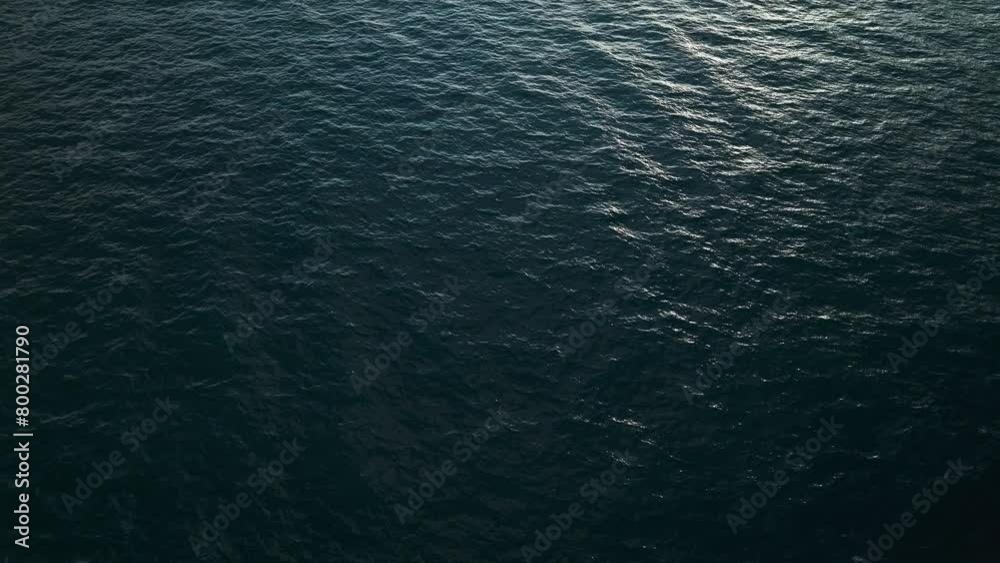 Aerial top down descends on serene water texture with glow of sunset Aerial top down descends on serene water texture with glow of sunset