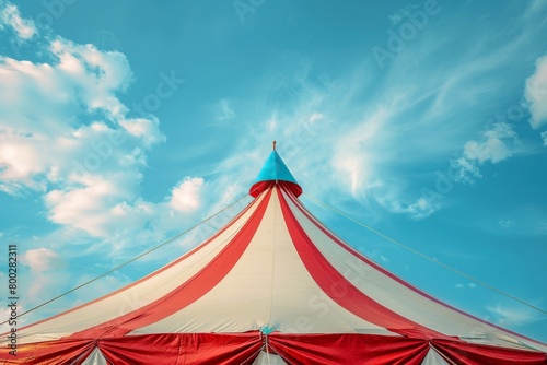 Red and white circus tent with blue star cover under sunny sky