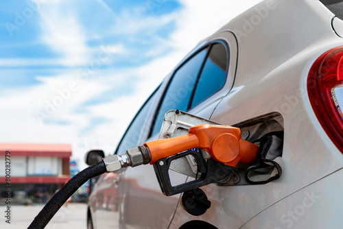 Car fueling at gas station. Petrol pump filling fuel nozzle in fuel tank of car at gas station. Petrol industry and service. Petrol price and oil crisis concept