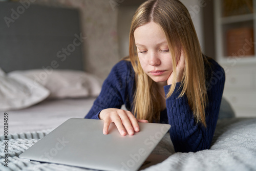 Unhappy Teenage Girl Closing Laptop Lying On Bed At Home Anxious About Social Media Online Bullying