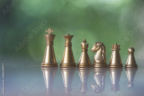 Sets of golden chess pieces on nature background. The photo of gold chess, king, rook, bishop, queen, knight, and pawn. © Dontree