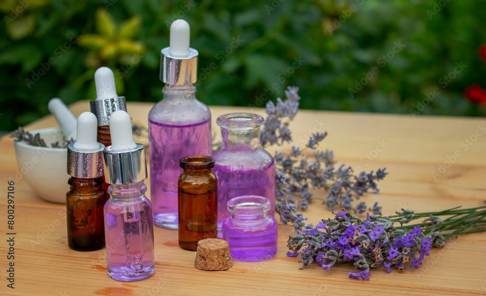 Glass bottle of lavender essential oil on a wooden background. Glass bottle of lavender essential oil on a wooden background.