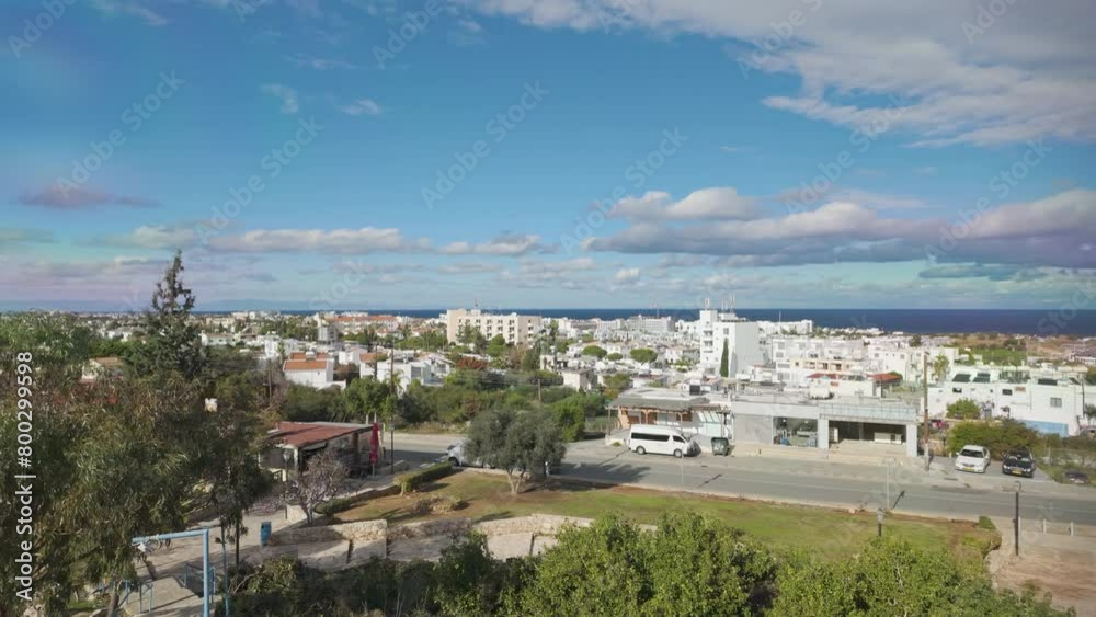 Panoramic view of Protaras, showing a spread of buildings and greenery leading to the blue waters of the sea, under a sky dotted with clouds Panoramic view of Protaras, showing a spread of buildings and greenery leading to the blue waters of the sea, under a sky dotted with clouds
