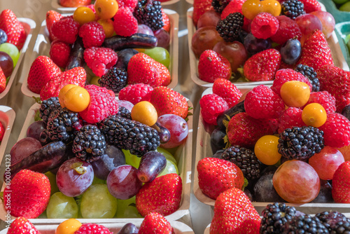 August 10, 2024-Vancouver, BC, Canada-Close up of boxes of colorful fresh organic berries on display at a farmers' market.