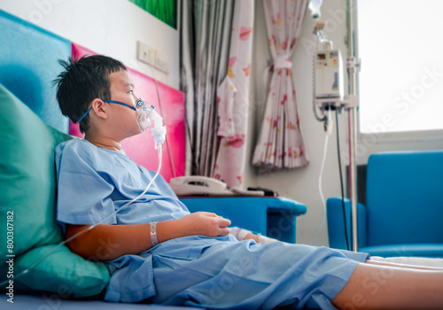 Sick Kid with asthma medicine. Ill child lying in bed. Bedroom or hospital room for young patient. Healthcare and medication.