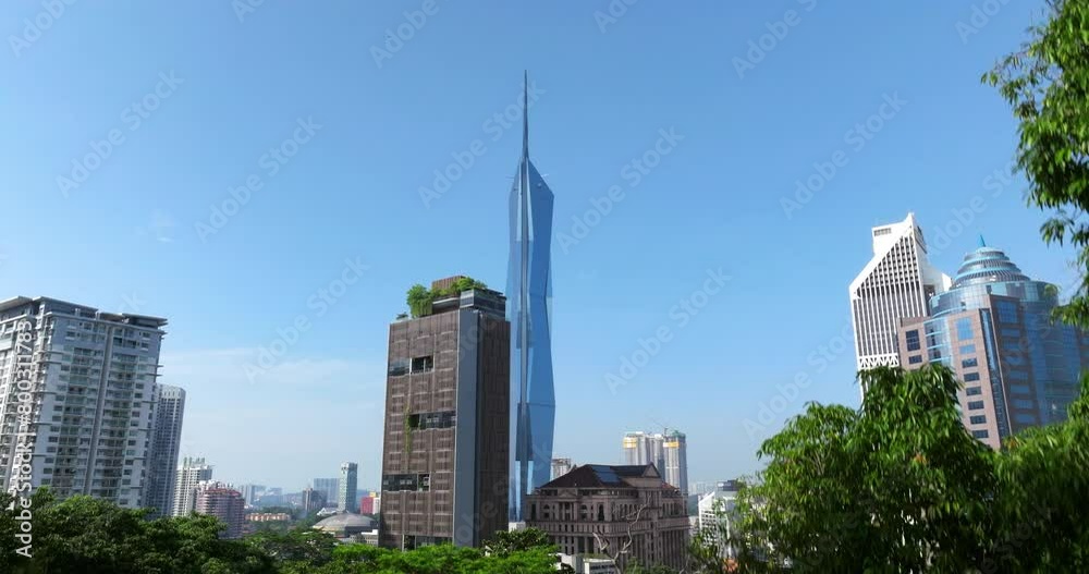Ascending Reveal Behind Foliage Of Famous Merdeka Tower In Kuala Lumpur, Malaysia. wide shot Ascending Reveal Behind Foliage Of Famous Merdeka Tower In Kuala Lumpur, Malaysia. wide shot