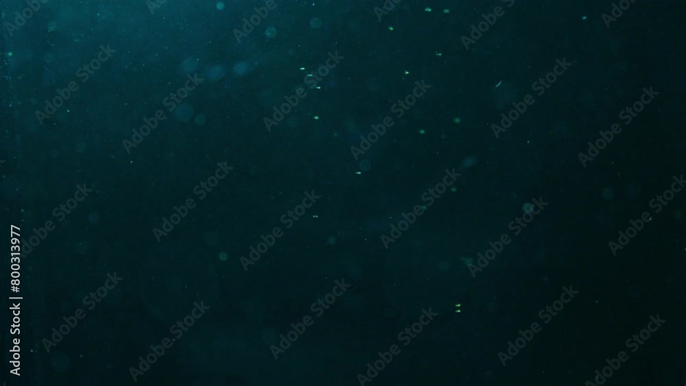 Slow motion, deep blue and black, liquid tank, small molecules falling Slow motion, deep blue and black, liquid tank, small molecules falling