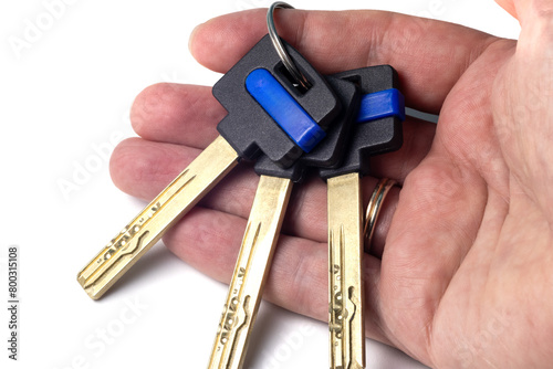Bunch of modern door keys on the hand palm isolated on a white background. Keys with black plastic head and space for logo or name, close-up view