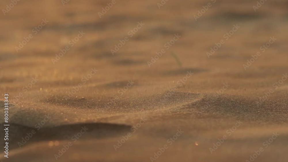 Small sand particles blowing over miniature dunes in slow motion