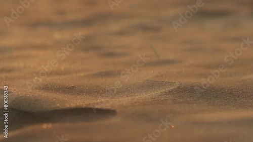 Small sand particles blowing over miniature dunes in slow motion