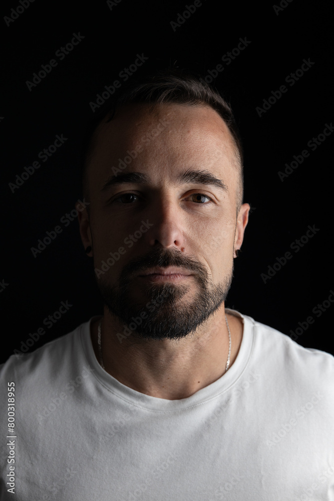 Portrait of man in studio with black background and half face with light and shadow Portrait of man in studio with black background and half face with light and shadow