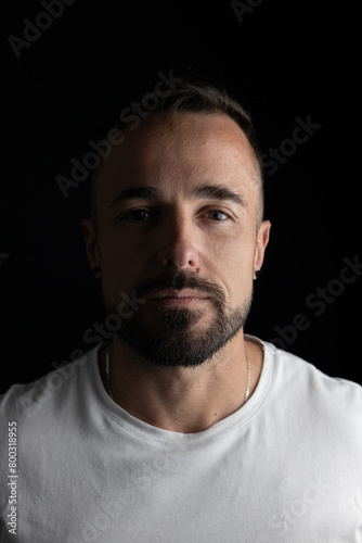 Portrait of man in studio with black background and half face with light and shadow