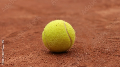 a tennis ball sits on a tennis court, ready to serve the ball © Wirestock
