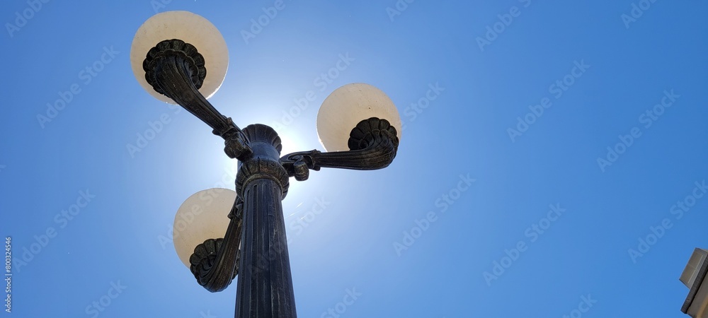 an old style street light that is on the side of a street