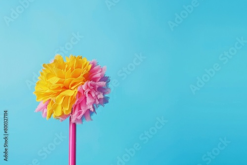 A vivid pink handled duster covered with dust particles stands out against a single-toned blue background portraying cleanliness photo
