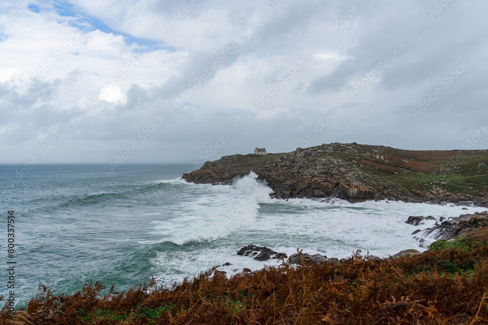 En automne, les fougères aux tons automnaux en premier plan, une mer agitée sous un ciel couvert à la Pointe du Millier, une atmosphère saisissante en Bretagne.