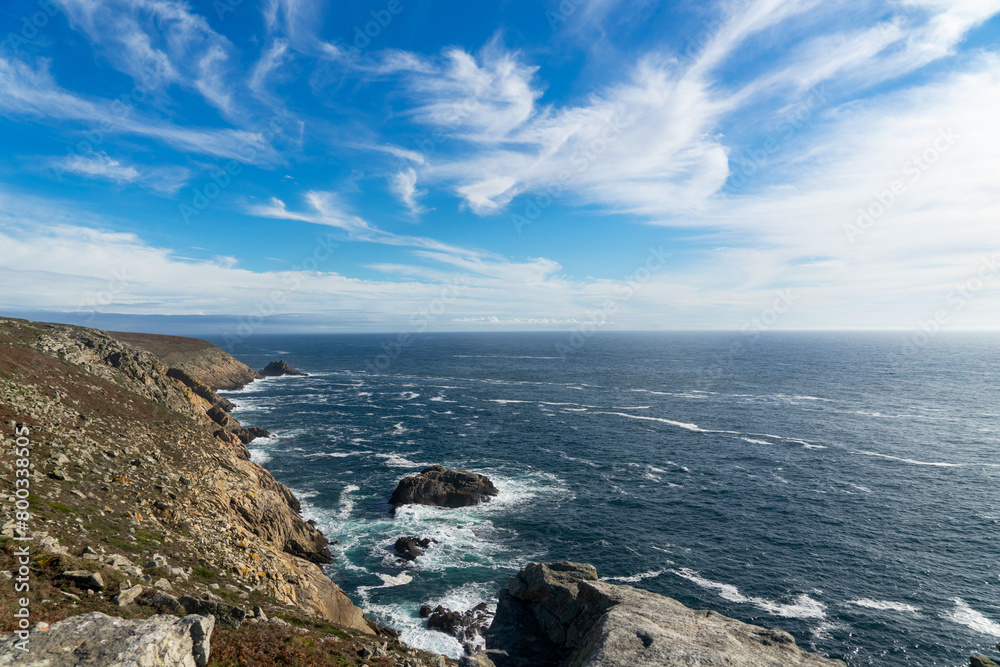 Côte sauvage, falaises rocheuses, eaux d'un bleu profond et écume à la Pointe du Raz, un paysage emblématique de la Bretagne.