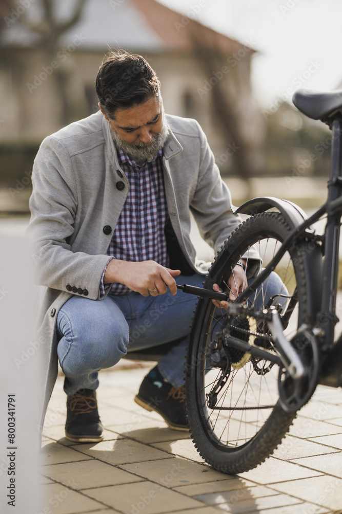 Man Inflating Bicycle Tire on Sidewalk Man Inflating Bicycle Tire on Sidewalk