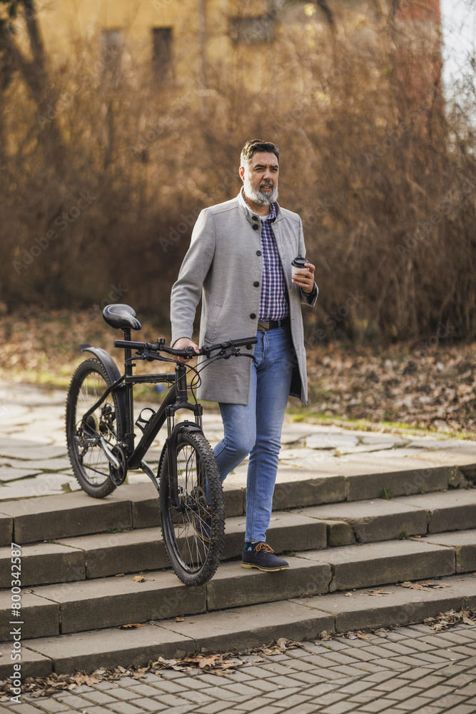 Obraz premium Man Walking Bike Down Stone Steps in Urban Park