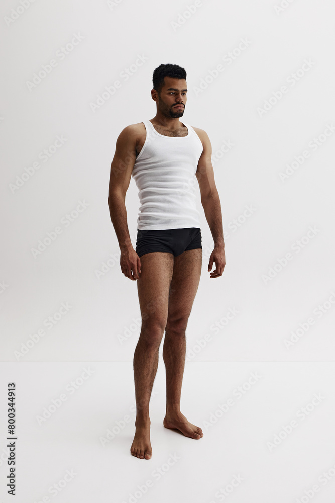 Full-length image of handsome African-American man standing shirtless in black boxes isolated on white background. Masculinity. Concept of male beauty, sport, body care, health, fitness Full-length image of handsome African-American man standing shirtless in black boxes isolated on white background. Masculinity. Concept of male beauty, sport, body care, health, fitness